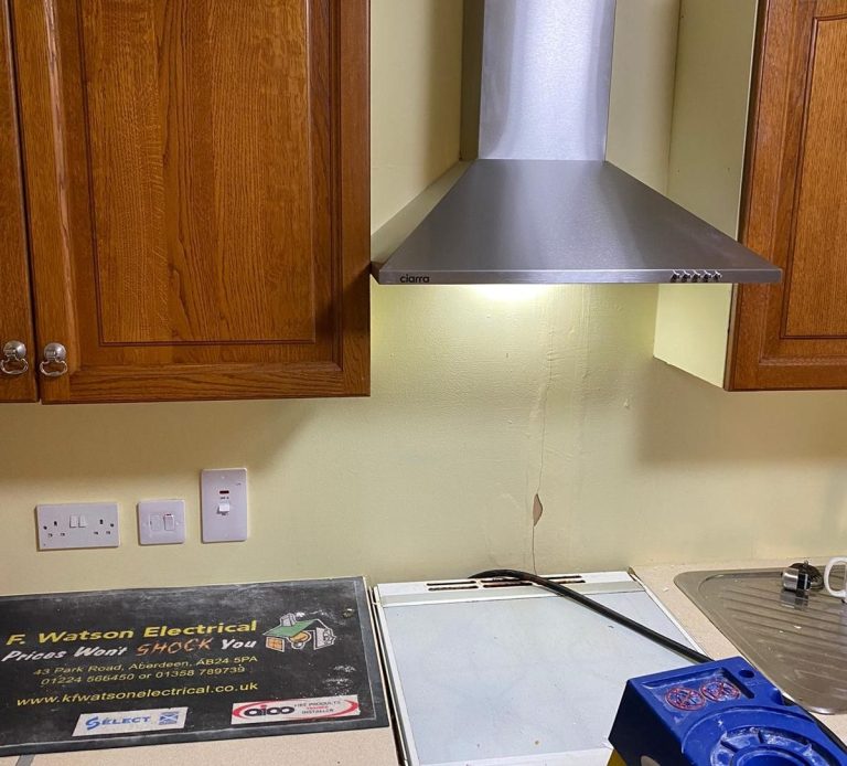 Domestic kitchen with electric hob and extractor fan being worked on by KF Watson engineers