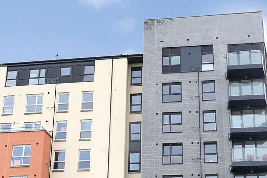 Grey and white rendered block of smart, modern flats with balconies