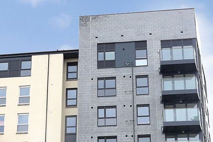Grey and white rendered block of smart, modern flats with balconies